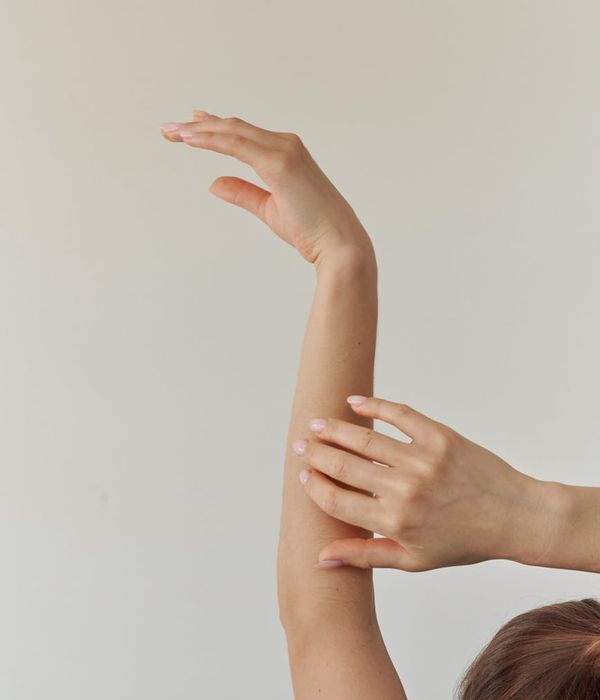 Woman in a calm yoga pose on a light lilac background.